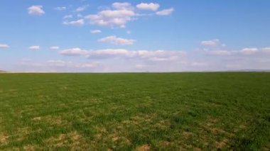 Çiftlik arazisi ve bulutlu mavi gökyüzü.