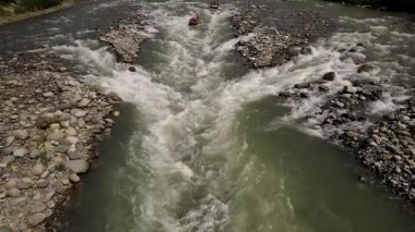 Rafting sporunun yüksek akışlı, azgın bir nehirde çekilmiş görüntüsü.