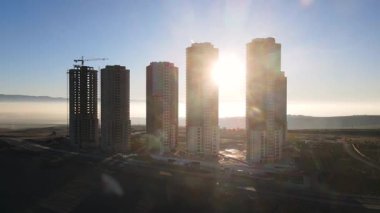 Şehir ve binalar arasındaki günbatımı görüntüleri. Binaların üzerinde bulutların dansı. Zaman aşımı tekniğiyle yakalanan bulut hareketleri.