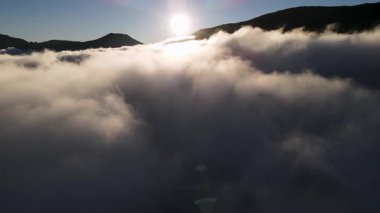 Sarp kayalıklardan oluşan sisli, bulutlu, dumanlı dağlar. Ulaşılması zor zirveler.