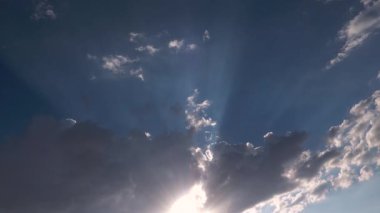 Yağmur ve fırtına bulutlarıyla kaplı kasvetli bir gökyüzünde, bulutların arasındaki ışık demetlerinin zamanlanmış görüntüleri..