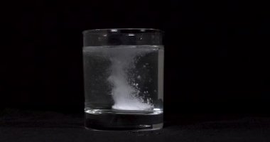 Siyah zemin üzerinde eriyen ilaçların yavaş çekim görüntüleri..