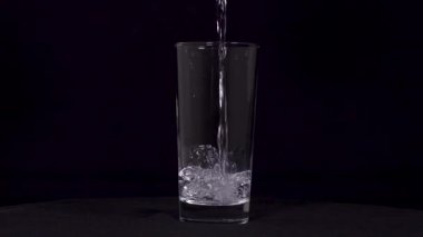 Suyun siyah arkaplanda cama aktığını gösteren yavaş çekim görüntüleri..