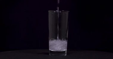 Siyah zemin üzerine dökülen soda ve limonların yavaş çekim görüntüleri..