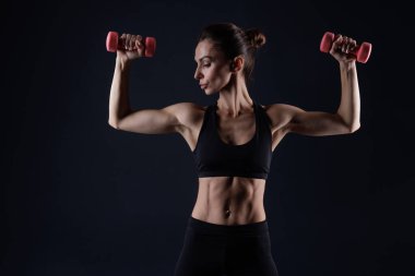 Beyaz elbiseli, halterli spor yapan, arka planda spor yapan atletik bir kız.
