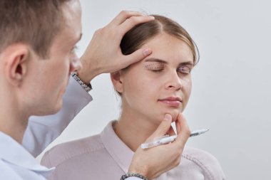 Plastik cerrah Blepharoplasty ve Blepharoplasty ameliyatına hazırlanıyor.