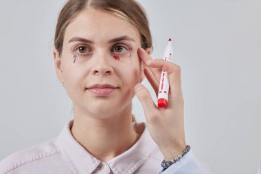 Plastik cerrah Blepharoplasty ve Blepharoplasty ameliyatına hazırlanıyor.