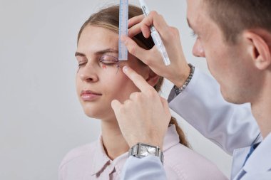 Plastik cerrah Blepharoplasty ve Blepharoplasty ameliyatına hazırlanıyor.