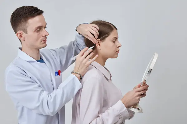 Otoplasty markup for surgical reshaping of the pinna, or outer ear for correcting an irregularity and improving appearance. Surgeon doctor marking girl ear before otoplasty cosmetic surgery