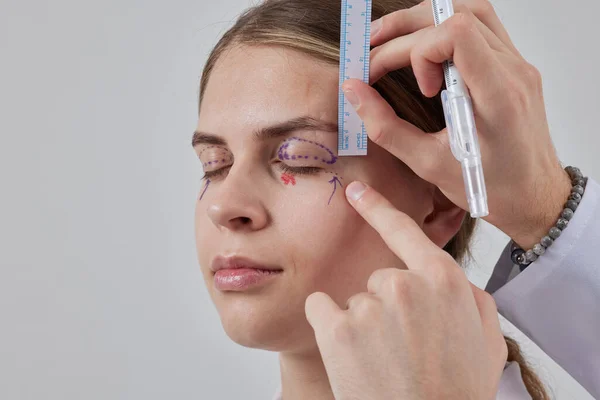 Plastik cerrah Blepharoplasty ve Blepharoplasty ameliyatına hazırlanıyor.