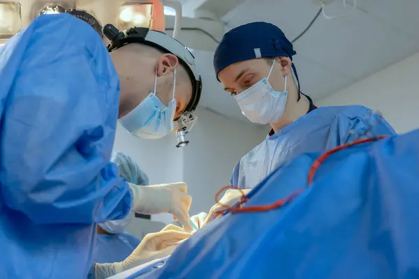 male surgeons perform surgery in operating room, plastic surgeon in operating room