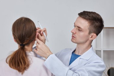 Pinna cerrahi yeniden şekillendirme için Otoplasty işaretleme, ya da düzensizlik düzeltmek ve görünümünü iyileştirmek için dış kulak. Ameliyat doktoru otoplasti estetik ameliyatından önce kızın kulağını işaretliyor.