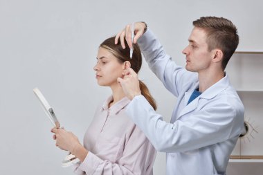 Doktor cerrah Otoplasty operasyonu için hazırlanıyor, Kulak estetiği, çıkıntılı kulakların düzeltilmesi.