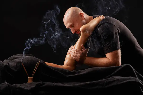 Przystojny Mężczyzna Masażysta Robi Masaż Nodze Dziewczyny Czarnym Tle Koncepcja — Zdjęcie stockowe