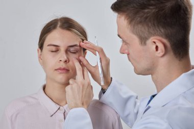 Plastik cerrah Blepharoplasty ve Blepharoplasty ameliyatına hazırlanıyor.
