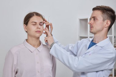 Plastik cerrah Blepharoplasty ve Blepharoplasty ameliyatına hazırlanıyor.