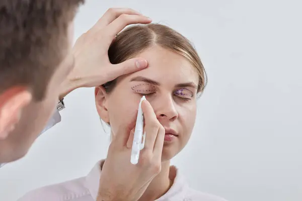 Plastik cerrah Blepharoplasty ve Blepharoplasty ameliyatına hazırlanıyor.