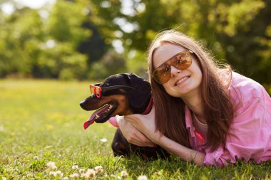 Güneş gözlüklü köpek ve genç kız güneşli günün tadını çıkarın.