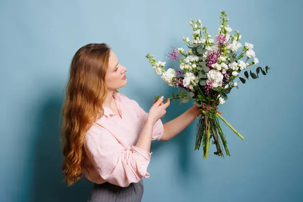 female florist makes a bouquet in a flower shop, spring bouquet