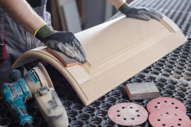 Erkek bir marangoz, mobilya fabrikasında zımpara makinesiyle ahşap mobilya cephesi, ahşap işleme konsepti.