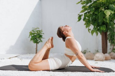 Yoga dışarıda geriniyor. Beyaz arka planda yoga yapan şişman kadının yan görünüşü, vücut bakımı konsepti, aşırı kilo vermeyle mücadele