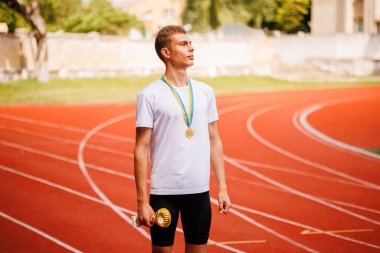 Kararlı bir atlet kırmızı bir pistin başlangıç çizgisinde çömelmiş bir pozisyonda, bir sürat yarışı başlatmaya hazırlanıyor.
