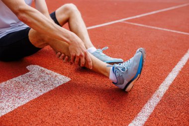 Koşu, koşu, koşu, koşu, sakatlık konsepti ve spor müsabakalarından sonra bacağını tutan sporcu sakatlandı.