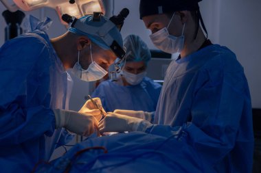 Blepharoplasti, göz kapaklarındaki kusurları düzeltmek için estetik ameliyat göz bölgesini estetik olarak değiştirmek için. Bir klinikte yağ birikintilerinin alınması, bir cerrahi ekip bir operasyon gerçekleştirir.