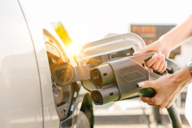 a girl charges her electric car at a charging station, Environmentally friendly energy sources, green energy concept, solar energy clipart