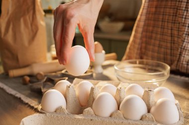 Mutfak masasının üstündeki kutudan tavuk yumurtasını mutfak atmosferine yakın plan çekiyoruz.