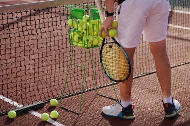 Tenis oyuncusu raket ve topu kalenin yanında tutuyor. Yaklaş. etkin eğlence kavramı