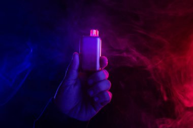 yakın plan, renkli duman arka planına karşı elektronik sigara, sigara içmenin zararları kavramı