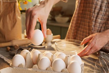Mutfak masasının üstündeki kutudan tavuk yumurtasını mutfak atmosferine yakın plan çekiyoruz.