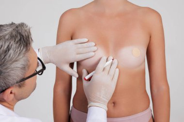 Ameliyattan önce eldiven takan plastik cerrah göğüslere iz bırakıyor, boyut ve göğüs şekillerinin değişmesi kavramını geliştiriyor.