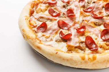 Beyaz arka planda pepperonili, jambonlu ve mantarlı yeni pişmiş bir pizzanın yakın çekimi..