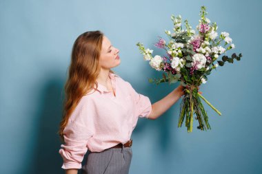 Kadın çiçekçi bir çiçekçide buket yapıyor, bahar buketi.