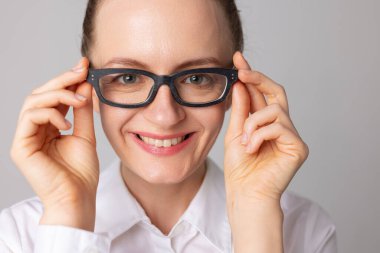 Bir kadın iyi bir görüş için gözlük takar ve gülümser çünkü daha iyi görebilir, iyi görüş konsepti, gözlük seçme