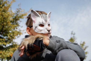 Kedi maskeli ve eldivenli genç Quadrobic yapıyor. Kuadrobik maskeli agresif genç kedi gibi zıplıyor.