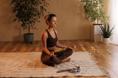 Evde yoga meditasyonu. Kız evde aromaterapi ve meditasyon yapıyor, sakin ol ve mutlu ol. Aromaterapi
