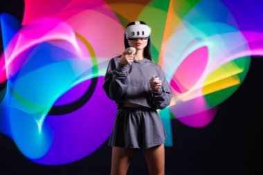 VR, AR, MR, XR Gelecek Teknolojileri. Neon. VR gözlüklü genç kız spor yapıyor ve oyun oynuyor. Modern cihazlar ve teknolojiler kavramı