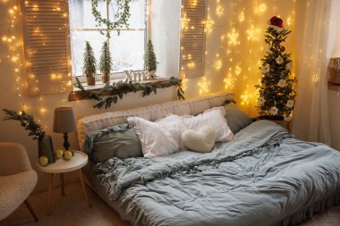 Sıcak bir atmosferde Noel ışıkları, dekor ve Noel ağacı olan İskandinav kışlık rahat yatak odası