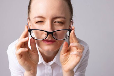 Beyaz gömlekli kadın portresi şaşı gözlükler, kötü görüş konsepti, oftalmoloji