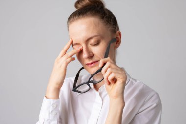 Görme sorunu. Yetişkin bir kadın yorgun gözlere masaj yapıyor, kötü görüş konsepti, göz doktoru.