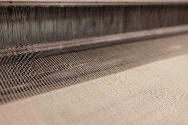 Dokuma tezgahındaki iplik çizgileri. Elbise ya da dokuma tezgahı etiketi. Kumaş endüstrisi için dokuma makinesi. Tekstil fabrikasında dokuma tezgahı.