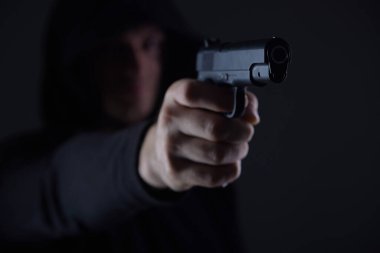 Silahlı bir soyguncu kameraya nişan alıyor. Kapüşonlu adam silahla tehdit ediyor. Silahlar bizzat ellerde. Katil ya da silahlı hırsız. Silahlı bir suçlu..