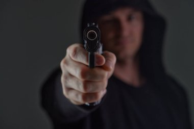 Silahlı bir soyguncu kameraya nişan alıyor. Kapüşonlu adam silahla tehdit ediyor. Silahlar bizzat ellerde. Katil ya da silahlı hırsız. Silahlı bir suçlu..