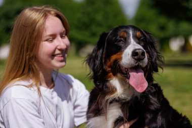 Bir evcil hayvan sahibi güneşli bir günde yeşil bir uçan disk kullanarak köpekleriyle kovalamaca oynar ve dışarıda eğlenir.