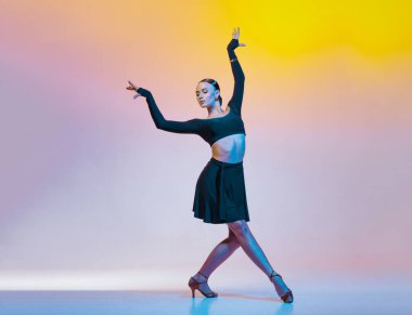 Siyah elbiseli zarif dansçı parlak bir arka planda Latin Amerika dansları yapıyor..