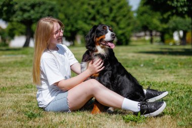 Bir evcil hayvan sahibi güneşli bir günde yeşil bir uçan disk kullanarak köpekleriyle kovalamaca oynar ve dışarıda eğlenir.