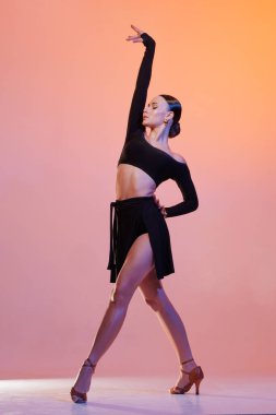 Siyah kıyafetli kendinden emin bir bayan dansçı canlı stüdyo ışıkları altında dinamik bir duruş sergiliyor dans konsepti, dersler, okul...